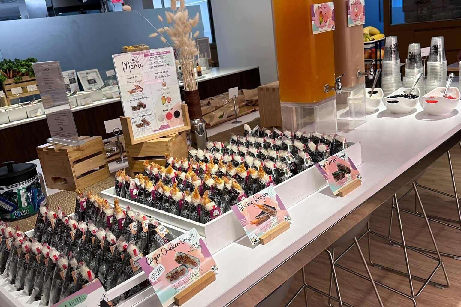 Yaya Tea onigiri display with ginger chicken, shrimp and vegan varieties at a catering station.