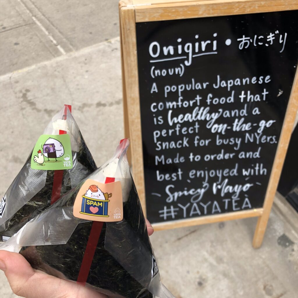Handmade Japanese onigiri rice balls at Yaya Tea with an onigiri definition sign.